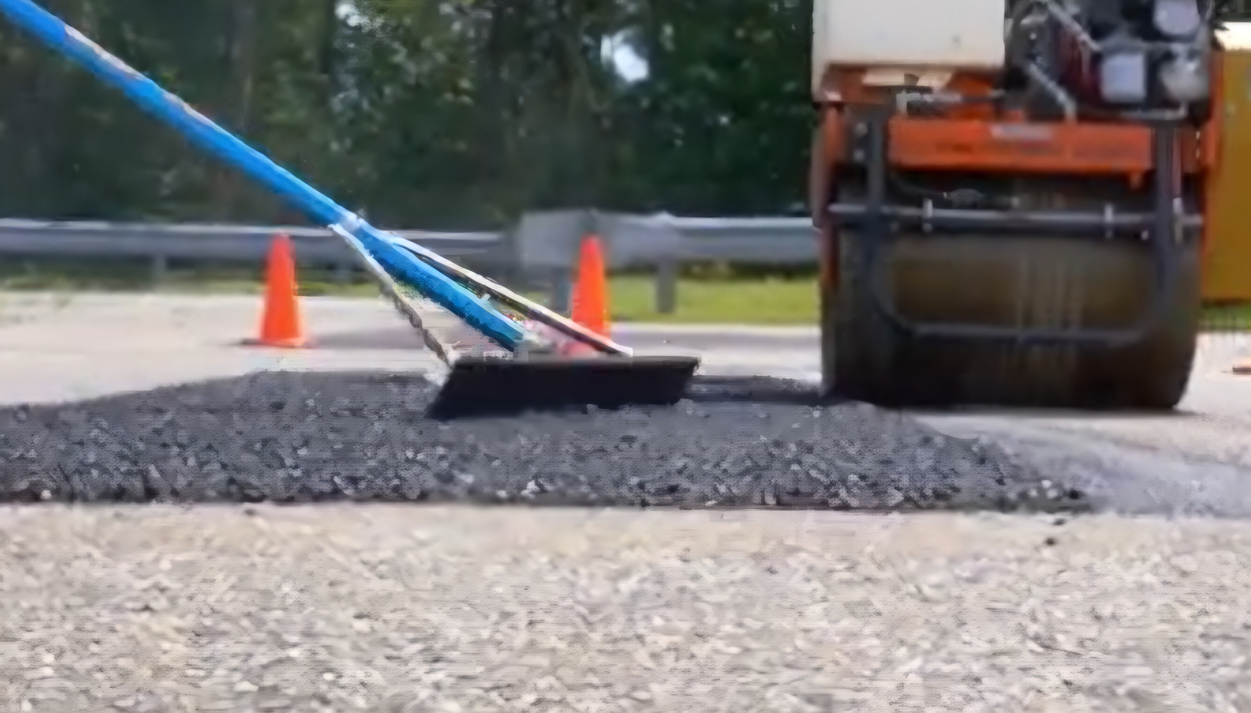 Utility cut finishing — squeegee detail on hot asphalt